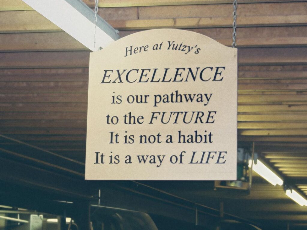 yutzy wood working shop sign that says Excellence is our pathway to the future. it is not a habit. it is a way of life.